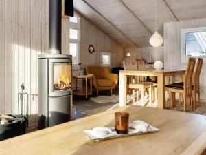 sala de estar con chimenea y mesa en Holiday home Fjerritslev XXXVII, en Fjerritslev