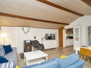 uma sala de estar com sofás azuis e uma lareira em Holiday home Gørlev IV em Gørlev