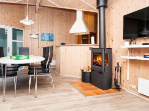 sala de estar con chimenea y mesa con sillas en Holiday Home Kirsebærvænget III, en Hejls