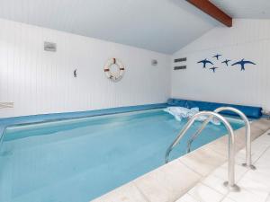 una piscina en una habitación con pájaros en la pared en Holiday home Oksbøl XII, en Oksbøl