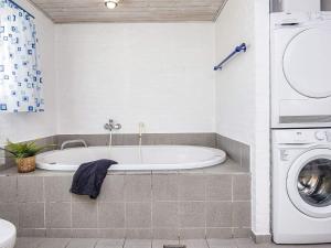 a bathroom with a tub and a washing machine at 6 person holiday home in Hemmet in Hemmet