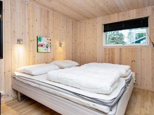 DalsgårdeにあるThree-Bedroom Holiday home in Silkeborg 3の窓のある木製の壁のドミトリールームのベッド1台分です。