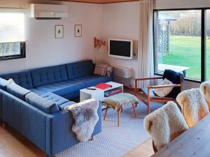 a living room with a blue couch and chairs at Holiday home Rødvig Stevns II in Rødvig