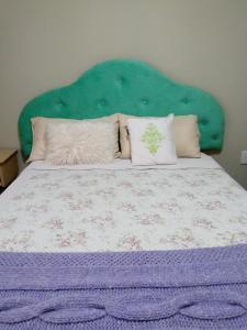 a bed with a green head board and pillows at Las Verbenas in San Rafael