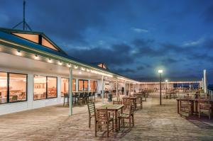 a patio with tables and chairs on a boardwalk at Panorama Hotel St Helens in St Helens