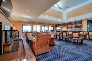 a restaurant with wooden tables and chairs and windows at Panorama Hotel St Helens in St Helens