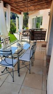 a glass table and chairs on a patio at l'Etoile de Nice in Colomars