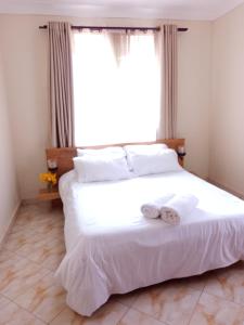 - une chambre avec un grand lit et des serviettes dans l'établissement Zen in Ibanda, à Kitwe