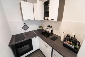 uma pequena cozinha com armários brancos e um forno preto em Exklusive 1-Zimmer Stadtwohnung in Bremen em Bremen