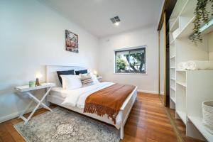 a bedroom with a bed and a desk and a window at Jupiter - 3BR WiFi BBQ in Thebarton