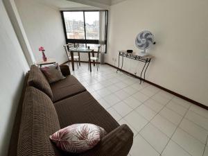uma sala de estar com um sofá e uma mesa em Pituba sol flat em Salvador