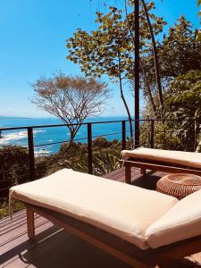 a bench on a deck with a view of the ocean at Veranera in Uvita