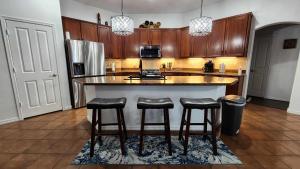 a kitchen with a large island with bar stools at Cozy Latitude home with pool in Goodyear