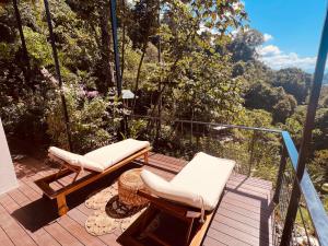 a balcony with two chairs and a view of the forest at Veranera in Uvita
