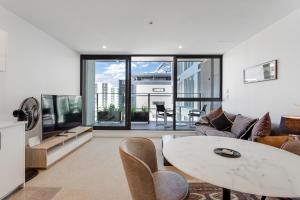 a living room with a table and chairs at The CityScape Apartment with Wi-Fi and Balcony in Auckland