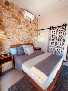 a bedroom with a bed and a stone wall at Veranera in Uvita