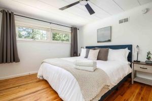 1 dormitorio con 1 cama grande y ventilador de techo en Chic Modern Home: Private Yard & Hot Tub!, en Traverse City