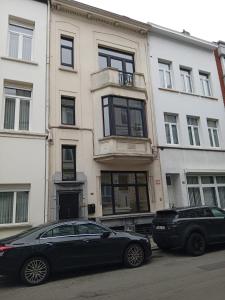 dwa samochody zaparkowane przed budynkiem w obiekcie ApartmentJacob1 w Antwerpii