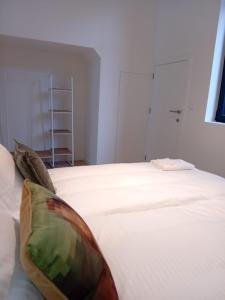 białe łóżko z dwoma poduszkami w obiekcie ApartmentJacob1 w Antwerpii