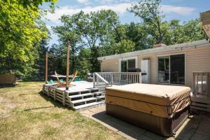 einen kleinen Wohnwagen mit einem Bett und einer Schaukel in der Unterkunft Chic Modern Home: Private Yard & Hot Tub! in Traverse City