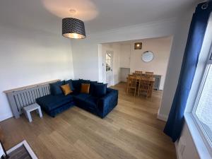 a living room with a blue couch and a table at Porth View Newquay in Saint Columb Minor