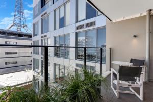 a balcony with a table and chairs on a building at The CityScape Apartment with Wi-Fi and Balcony in Auckland