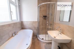 W łazience znajduje się wanna, umywalka i prysznic. w obiekcie Northumberland House 5 Bed Apartment Close To Beach with Parking by RockmanStays w Southend-on-Sea