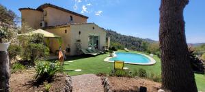 a backyard with a swimming pool and a house at l'Etoile de Nice in Colomars