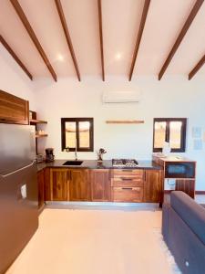 een keuken met houten kasten en een roestvrijstalen koelkast bij Tinamaste in Uvita