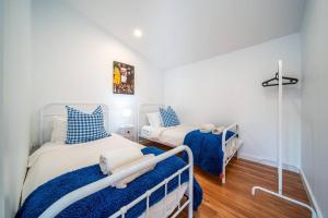 ein Schlafzimmer mit zwei Betten in Blau und Weiß in der Unterkunft Neptune - 2BR Private Pool WiFi in Thebarton