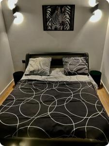 a bed with a black and white comforter in a bedroom at Appartement moderne vieille ville PARKING GRATUIT in Annecy