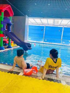 two young children playing in a swimming pool at Rio‘s home7 in Vung Tau