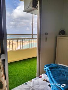 1 dormitorio con balcón con vistas a la playa en شقة بالإسكندرية علي البحر مباشر, en Alejandría