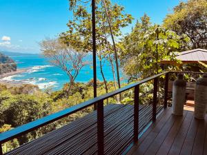 a balcony of a house with a view of the ocean at Tinamaste in Uvita