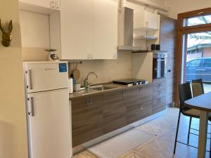 eine Küche mit einem weißen Kühlschrank und einem Tisch in der Unterkunft Ospedale Baggiovara - Modena appartamento Giardini 