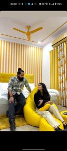 Un uomo e una donna seduti su un letto di Yellow Inn Guest House a Lucknow