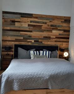 een slaapkamer met een gerestaureerde houten accentmuur bij Chalet Heiderose SPA - Kamin, Sauna & Wellness in Kluis