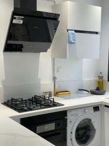 een keuken met een fornuis en een wasmachine bij Appartement de luxe lac 2 in La Goulette