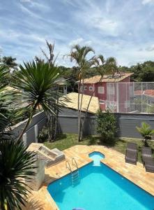 uma piscina num quintal com palmeiras em Casa 331 em Jaguariúna