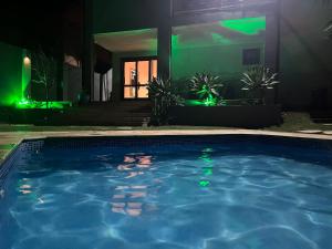 a swimming pool in front of a house at night at Casa 331 in Jaguariúna