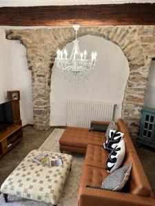 un salon avec un canapé et un lustre dans l'établissement 13th Century Stone House, à Faugères