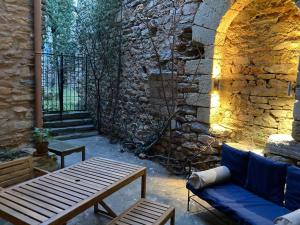 a patio with a bench and a stone wall at 13th Century Stone House in Faugères