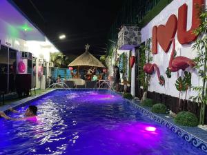 a woman swimming in a pool at night at Sharon’s Private Pool Villa in Mandaue City