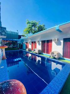 a swimming pool with chairs and a building at Sharon’s Private Pool Villa in Mandaue City
