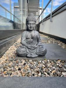 una estatua de un buddha sentado en el suelo en PISO SUPERIOR - Exklusives Apartment an der Promenade mit Rheinsicht & Loggia en Emmerich