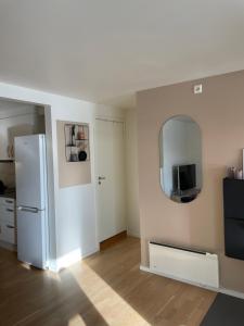 a kitchen with a white refrigerator and a mirror at Koselig og rolig leilighet med utsikt nær Preikestolen in Strand