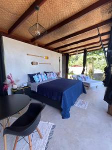 a bedroom with a bed and a table and chairs at Portogalo suíte com SPA in Angra dos Reis