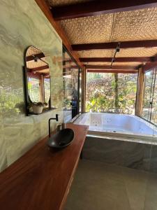 bagno con vasca e lavandino di Portogalo suíte com SPA ad Angra dos Reis
