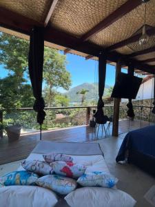 a bedroom with two beds and a balcony with a view at Portogalo suíte com SPA in Angra dos Reis