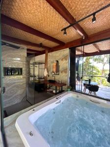 uma grande banheira de hidromassagem num quarto em Portogalo suíte com SPA em Angra dos Reis